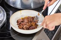 A person shreds meat cooked in the Presto 16-Quart Pressure Canner and Cooker