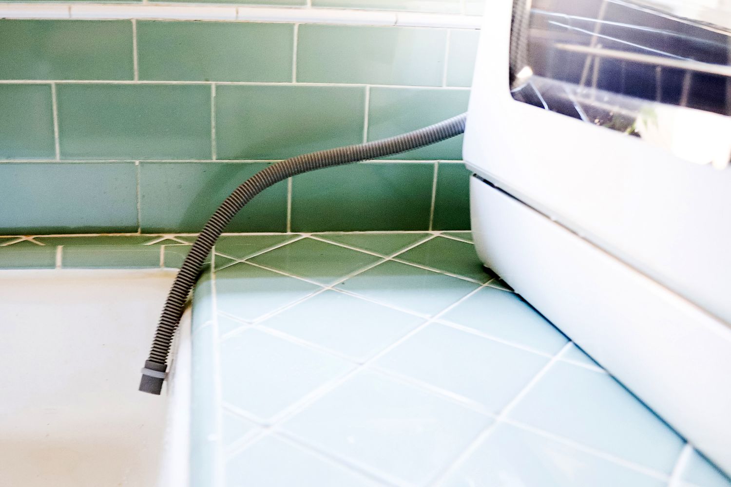 A countertop dishwasher draining into a sink.