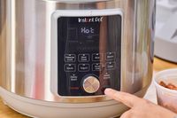 A person pressing the Start button on the Instant Pot Duo Plus 8-Quart Multi-Use Pressure Cooker V4