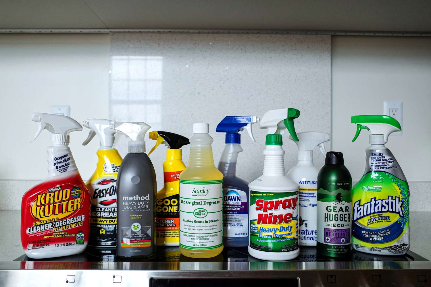 A collection of degreasers on a glass stovetop