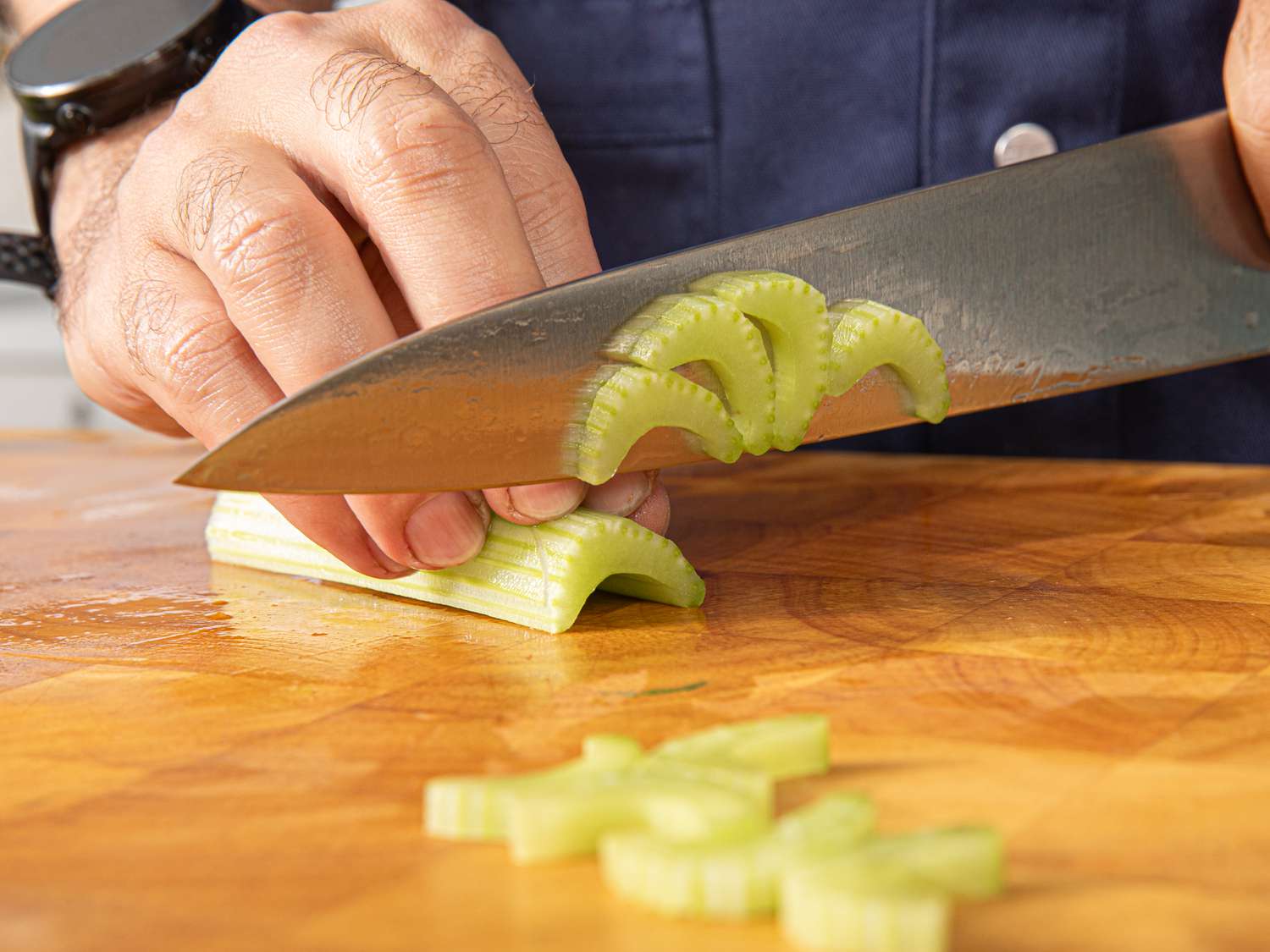Side view of cutting celery into half moons
