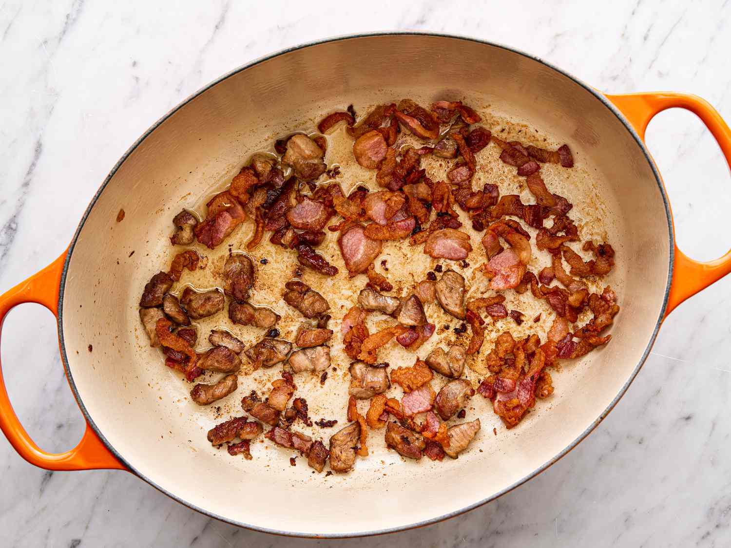 Overhead view of pork belly rendered in a Dutch oven.
