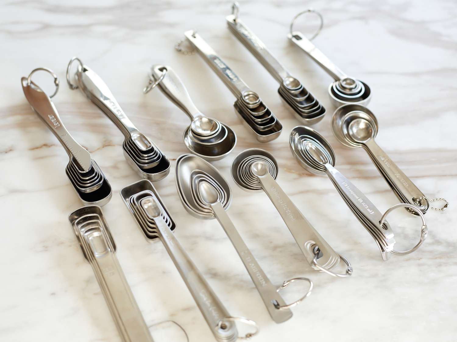 Measuring spoon sets side-by-side on a marble surface