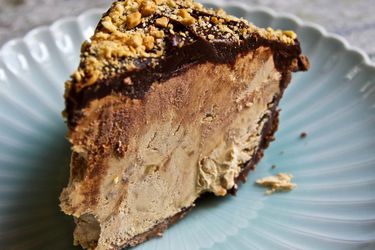 A slice of Snickers pie on a blue plate.