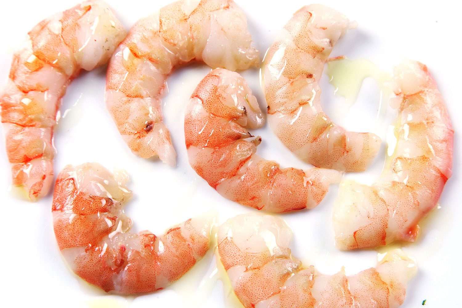 Plump- and juicy-looking shrimp that have been cooked sous vide on a white background