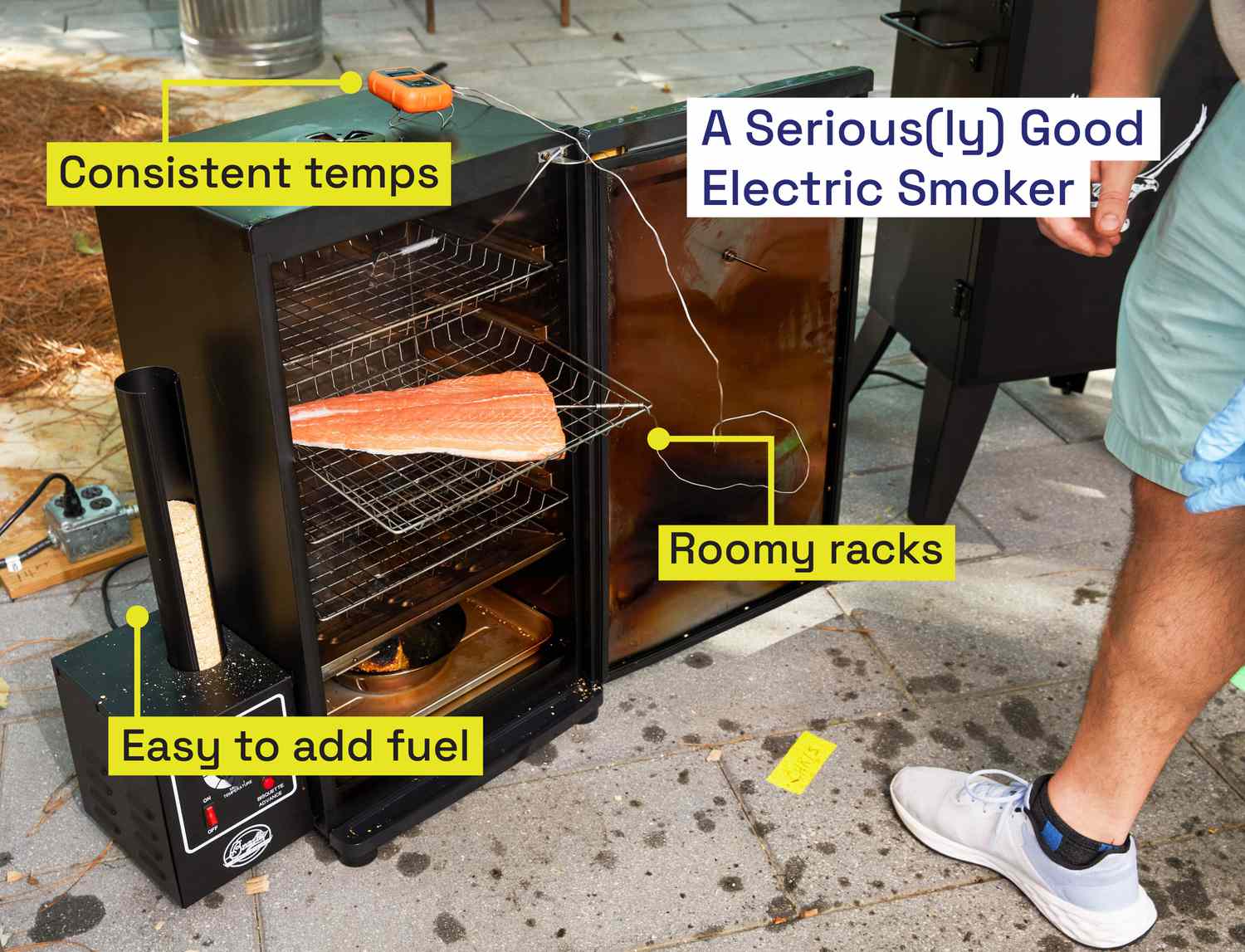 An electric smoker with a large piece of salmon on a middle rack.