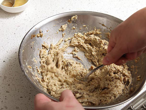 Mashing cooked and drained eggplant, garlic, and lemon juice into a rough paste, using a fork 