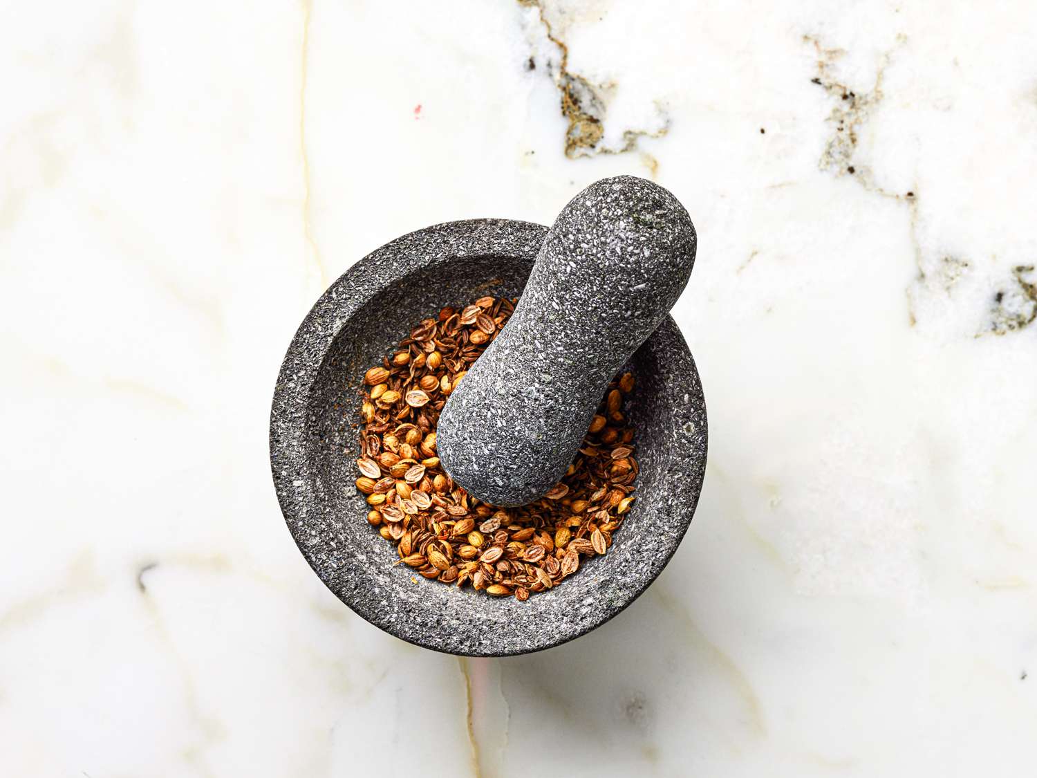 Overhead view of seeds in a mortar and pestle