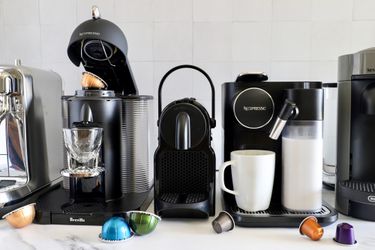 A number of Nespresso machines on a marble countertop.