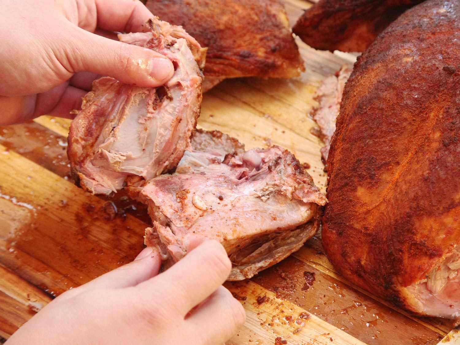 Remove hipbone from a smoked turkey thigh.