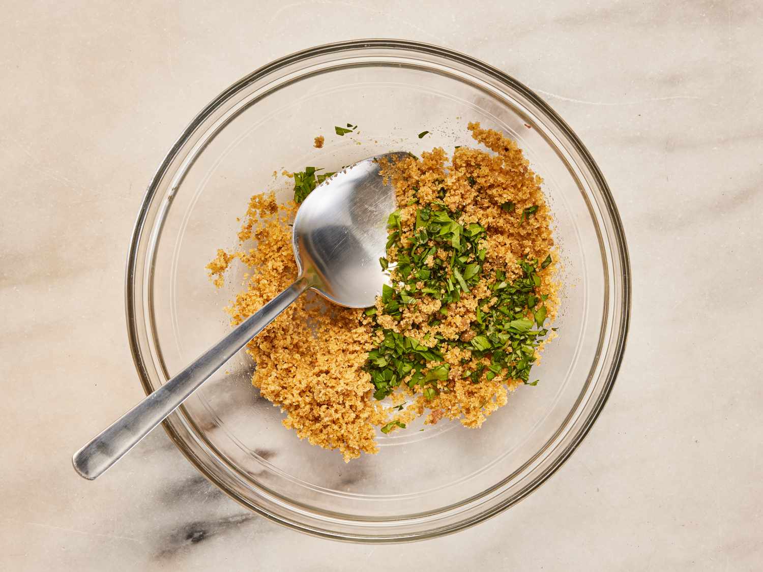 Overhead view of adding herbs to bread crumbs