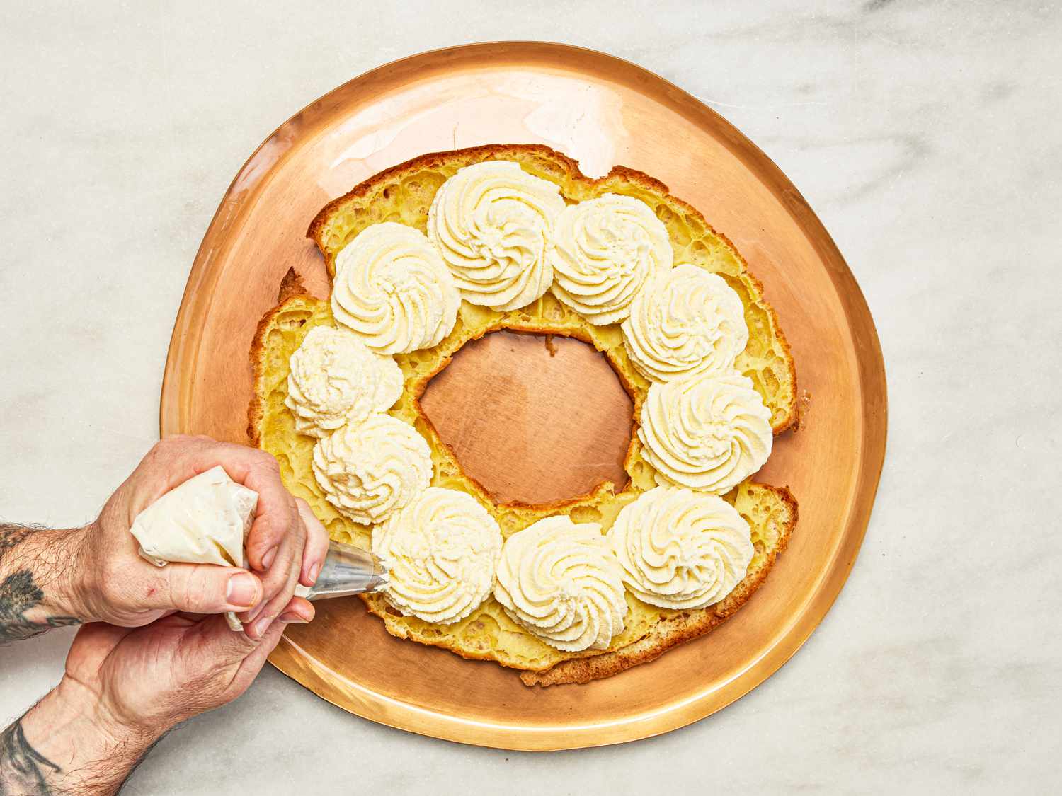 Overhead view of piping cream into choux