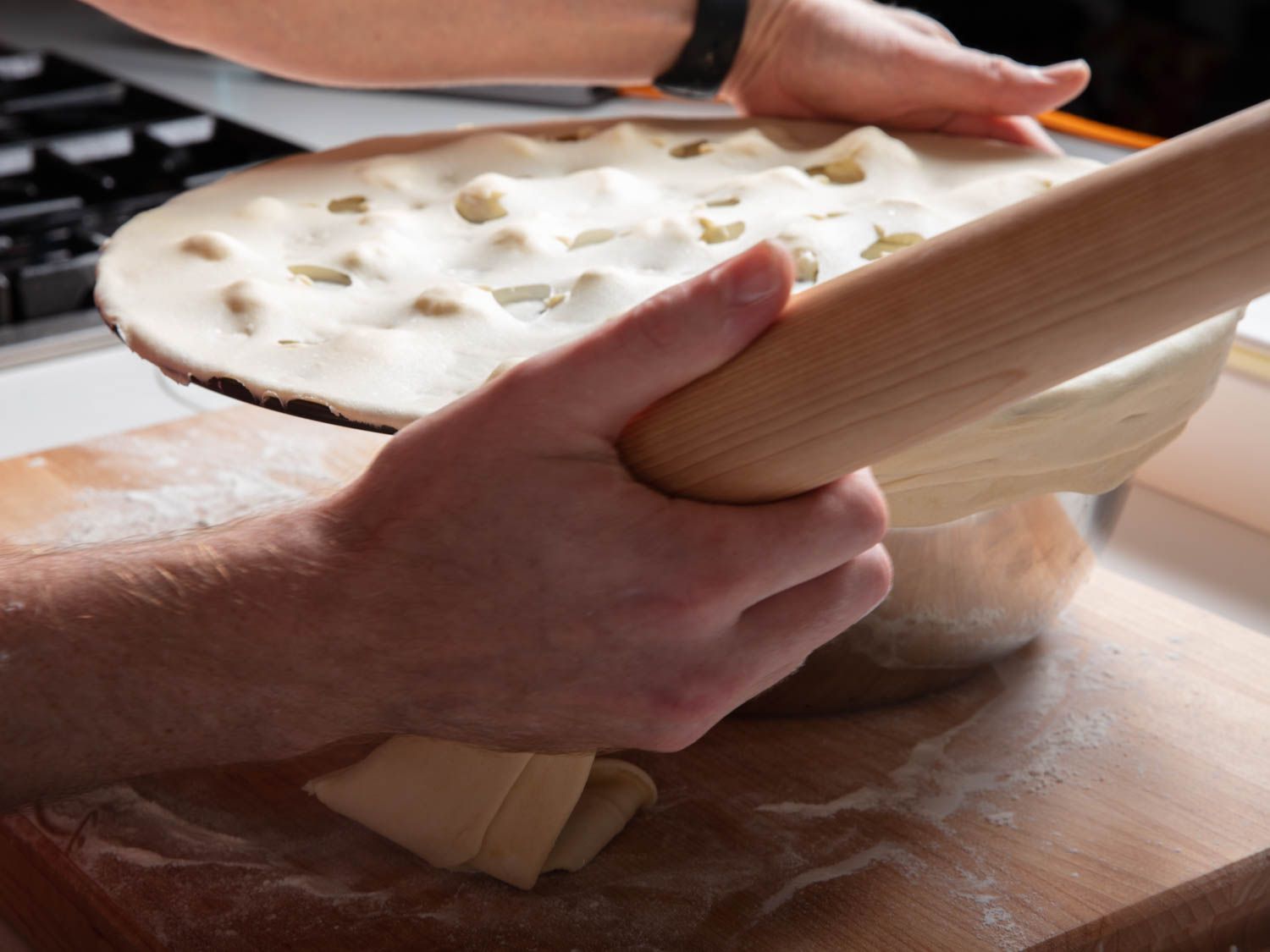 Removing overhanging dough with the edge of a rolling pin