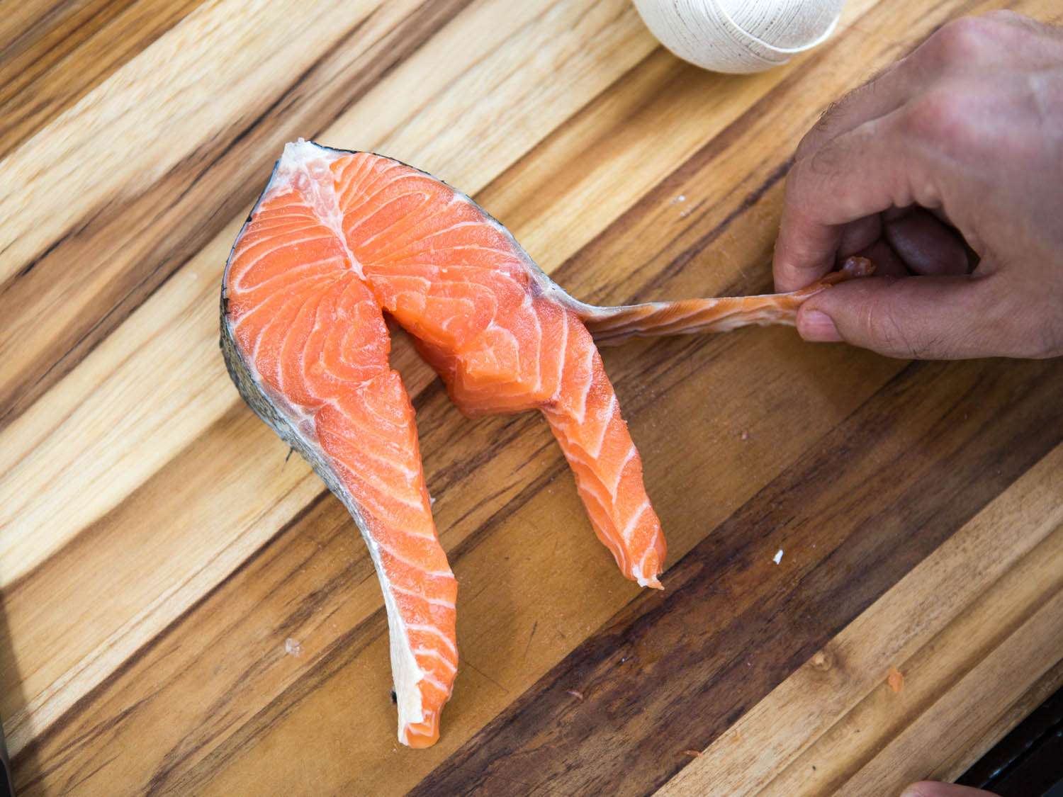 Showing the skin separated (but still attached) from one of the belly flaps of a salmon steak.