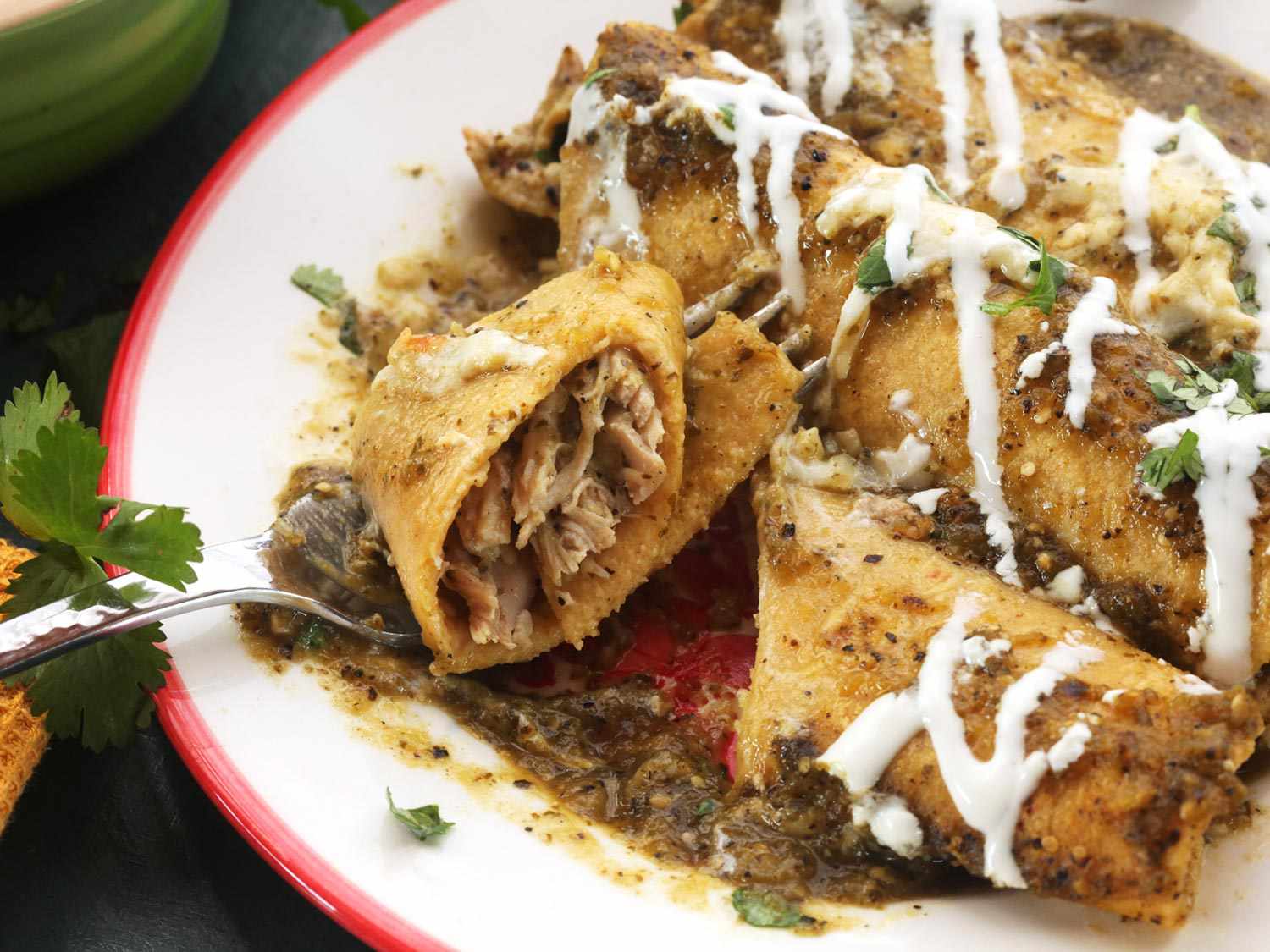 Close-up of creamy chicken enchiladas being eaten with a fork.