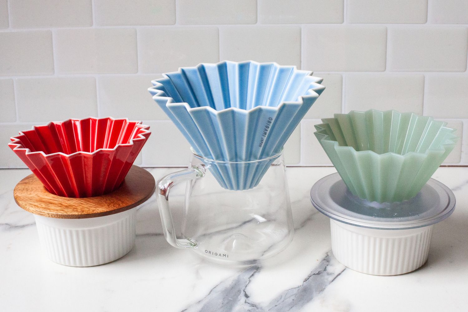 Three different sized Origami drippers sitting on a marbled surface