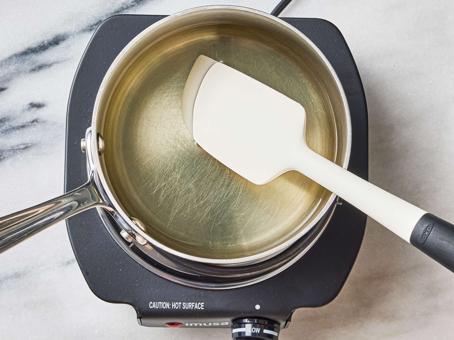 Overhead view of stirring syrup in pot 