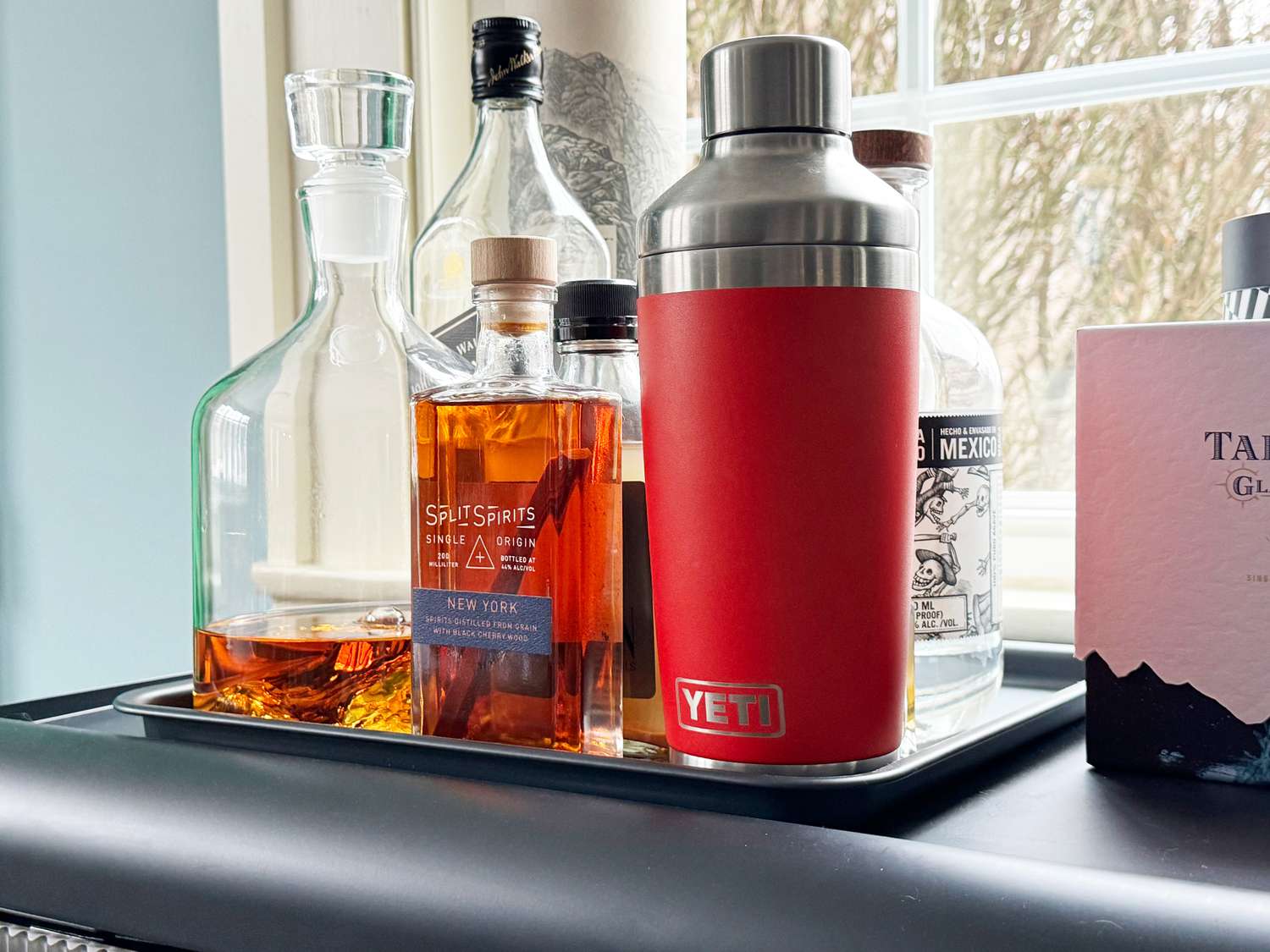A red Yeti cocktail shaker on a bar cart.