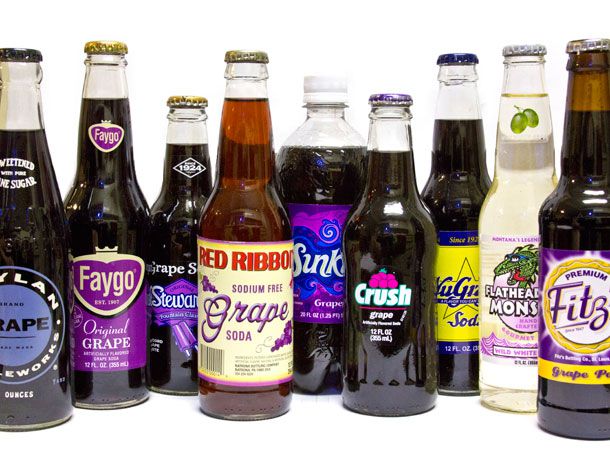 A collection of assorted grape sodas in bottles. 