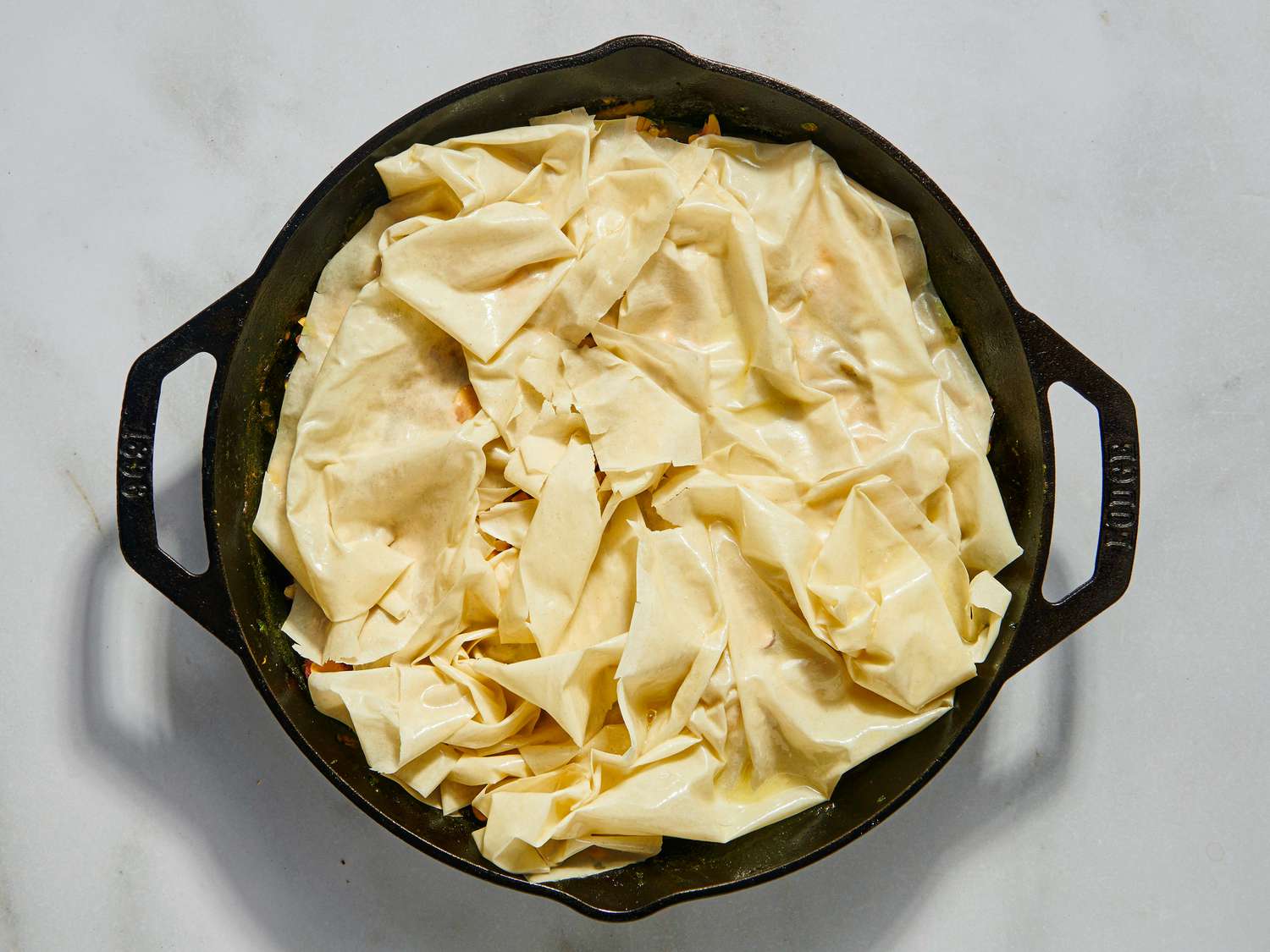 Overhead view of puff pastry added to skillet