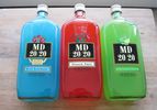 Three bottles of MD 20/20 next to each other: blue raspberry, dragon fruit, and kiwi-lemon. 