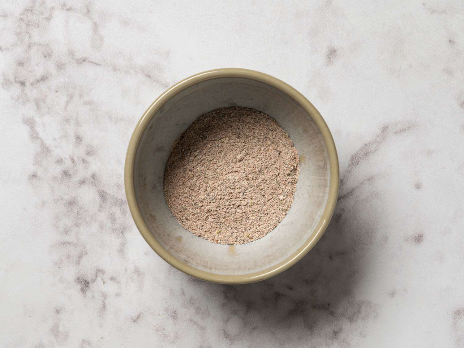A small ceramic bowl holding the Cajun spice blend.