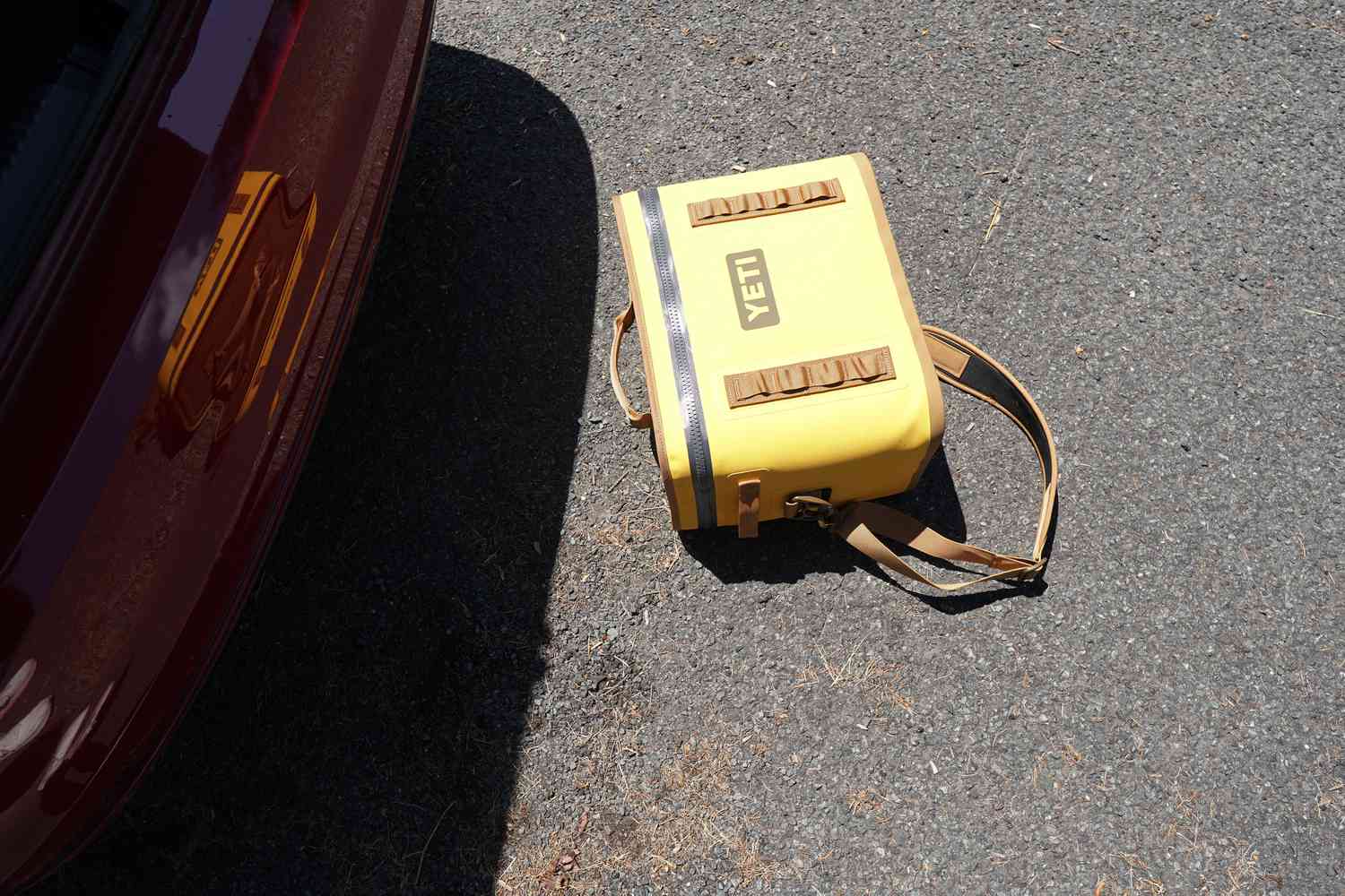 A yellow soft cooler on the ground