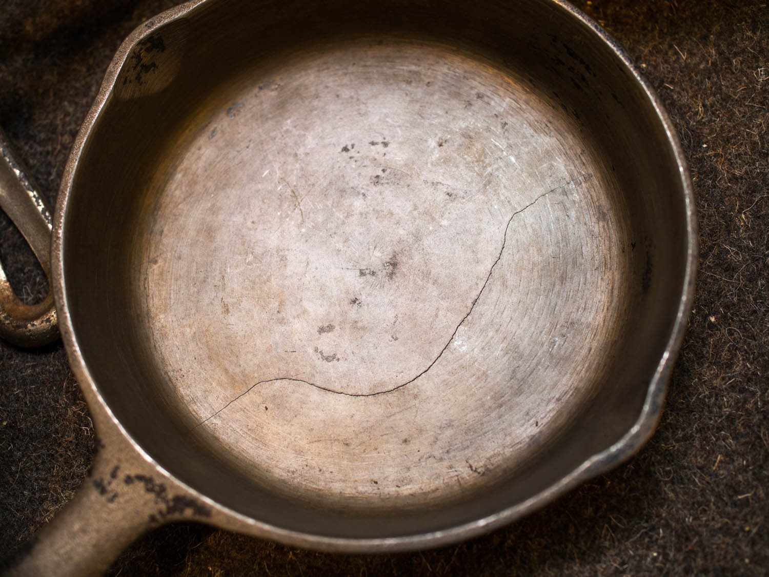 An overhead view of a cast iron with a crack down the center. 