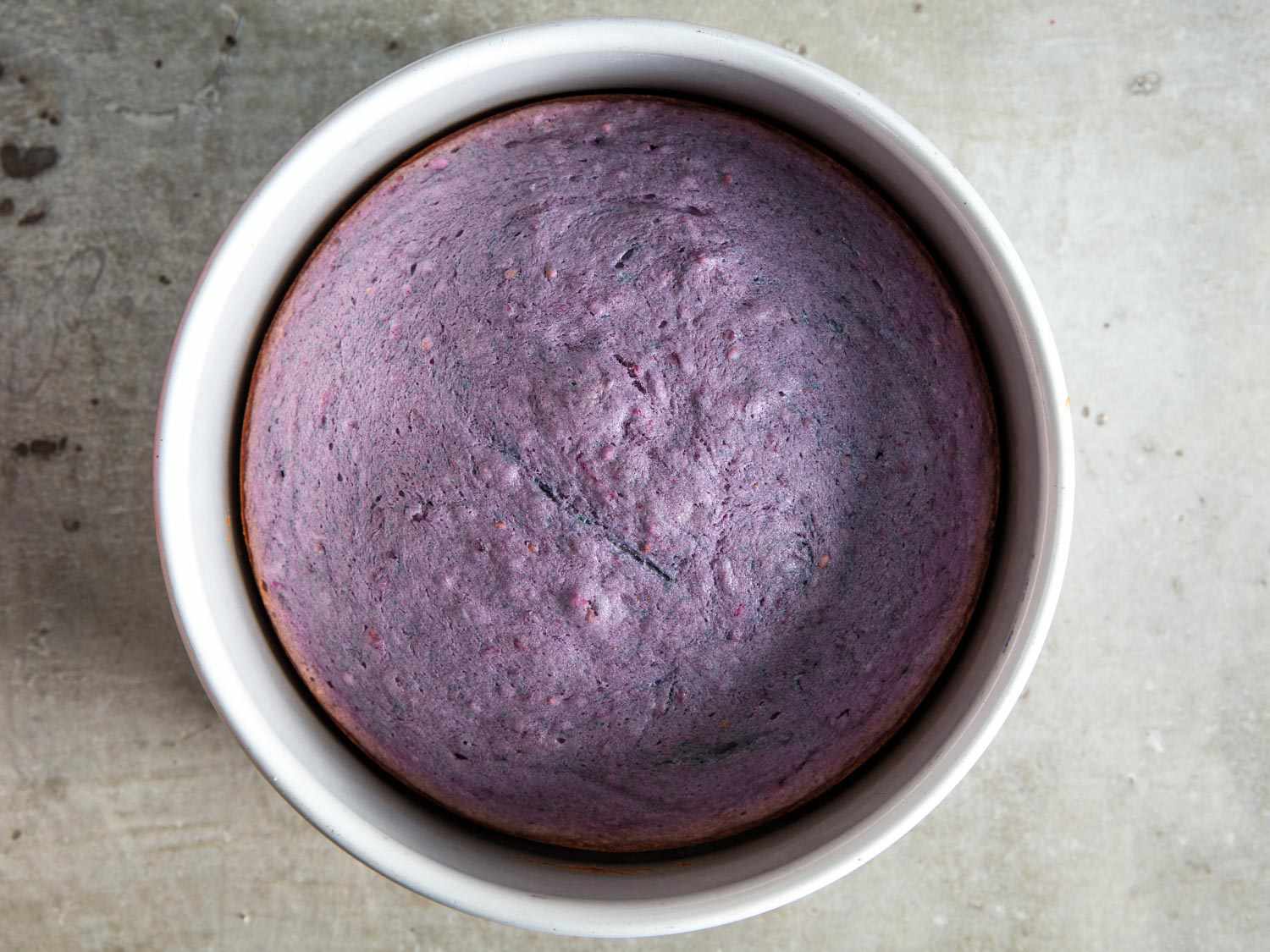 Overhead of a baked blackberry cake layer in an extra-deep cake pan