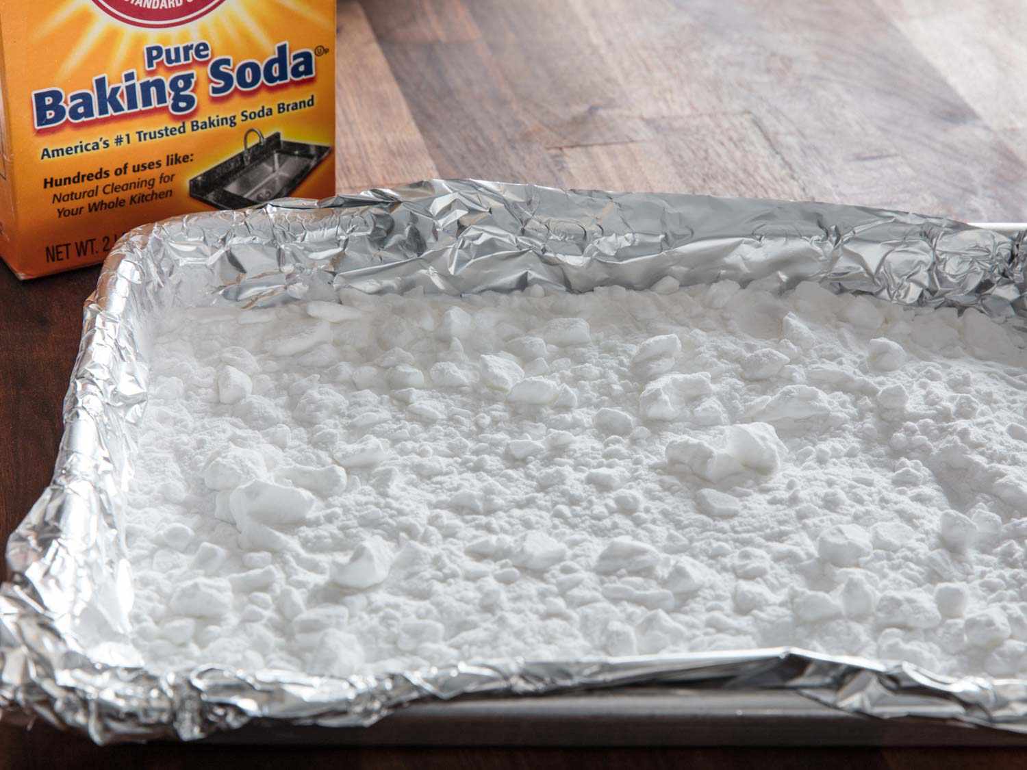 A foil-lined rimmed baking sheet full of baked baking soda.