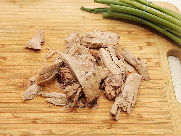 Shredded turkey thigh on a cutting board. 