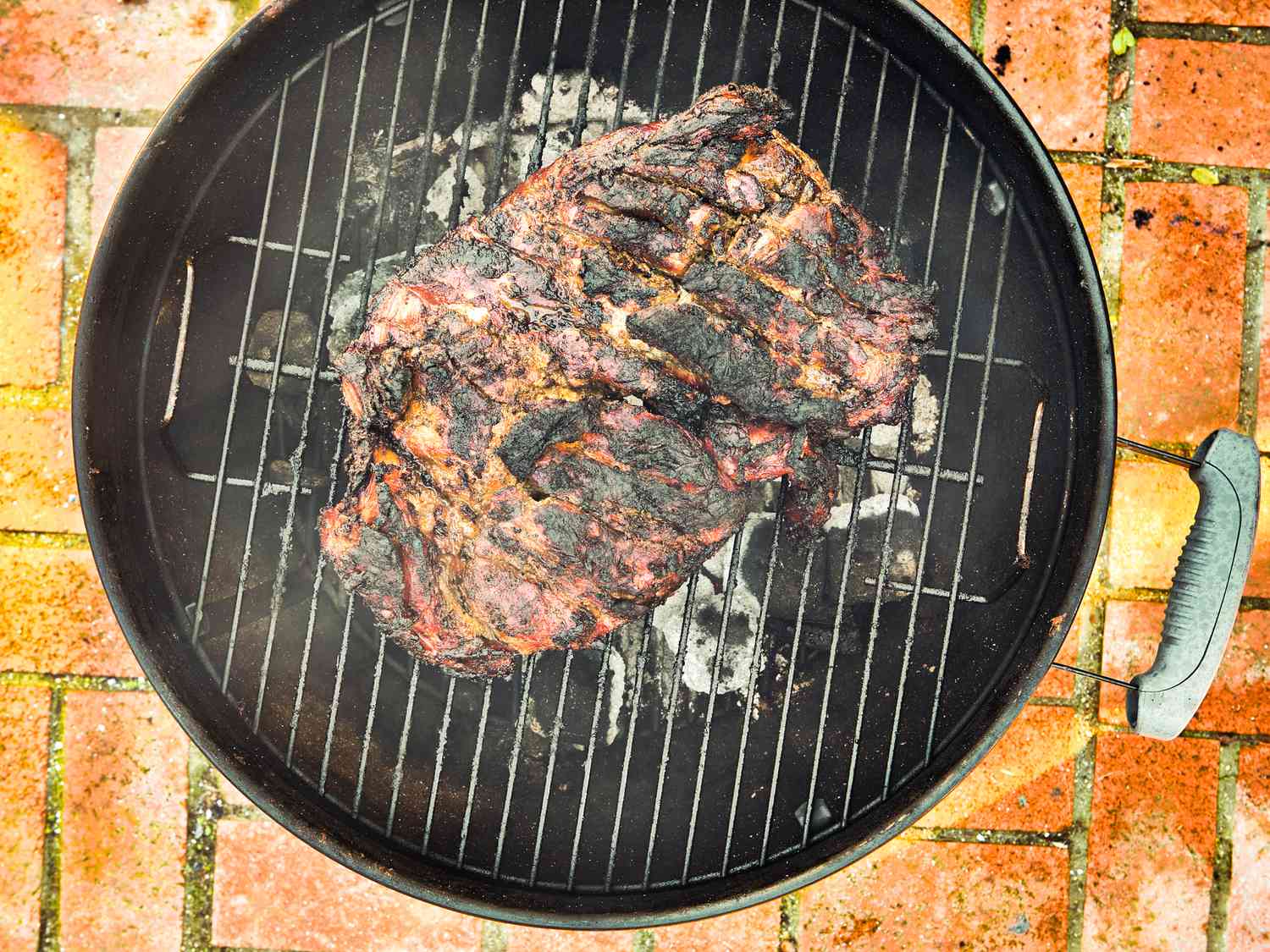 Overhead view of pork well charred on grill