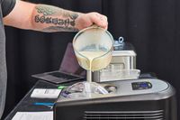 Hand pouring liquid ice cream base into Cuisinart ICE-100 Compressor Ice Cream and Gelato Maker