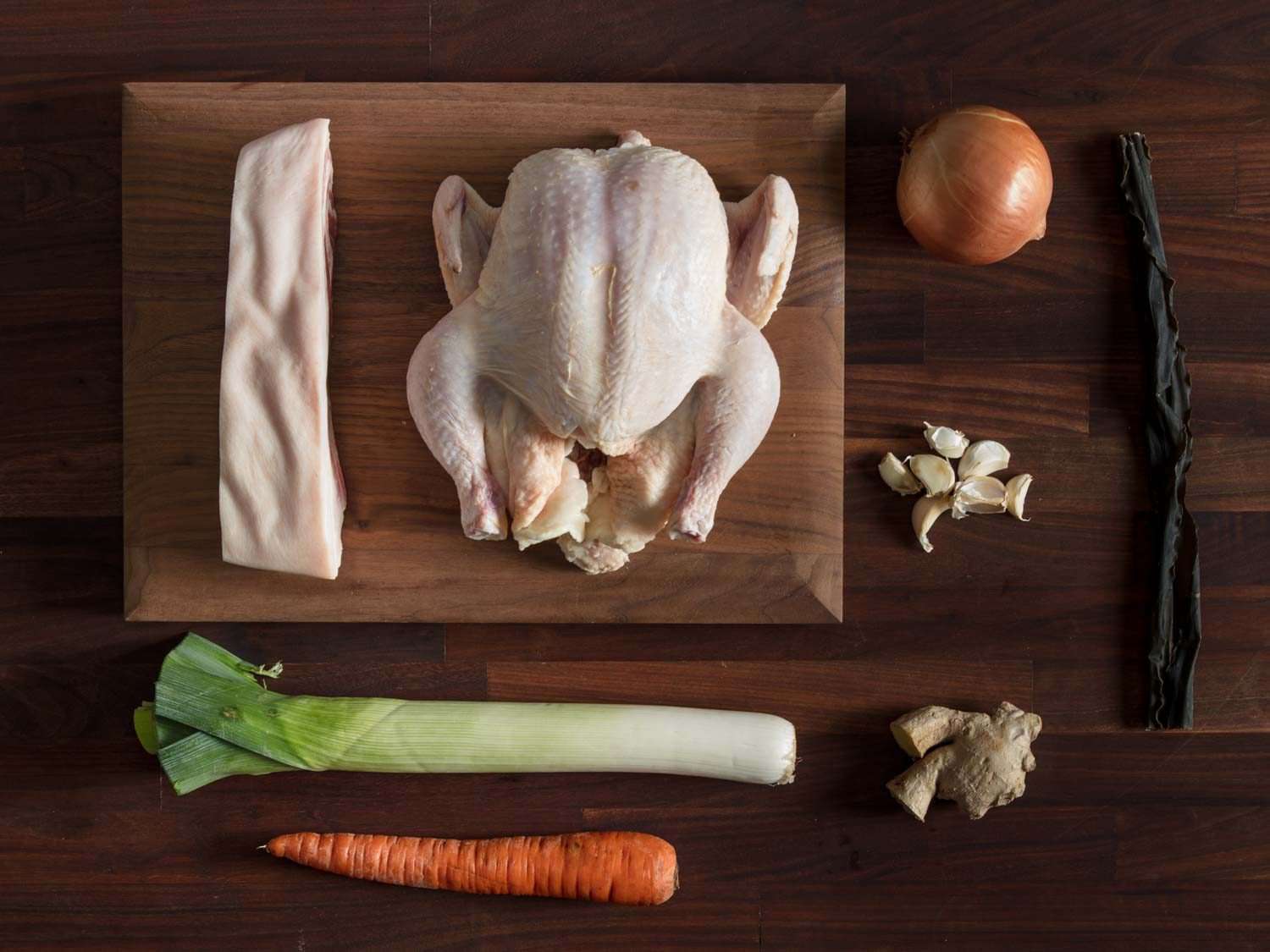 Ingredients for shoyu ramen broth: pork belly, whole chicken, onion, garlic, ginger, leeks, carrot
