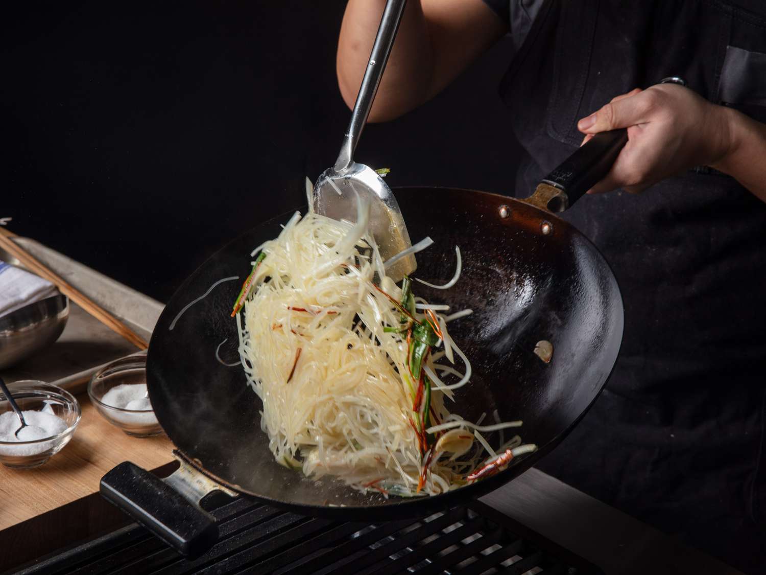 Potato strands being tossed in the wok.