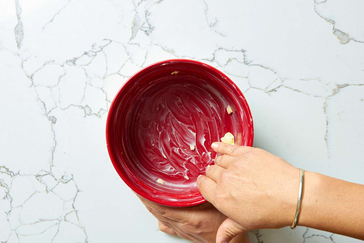 Greasing a red baking dish.