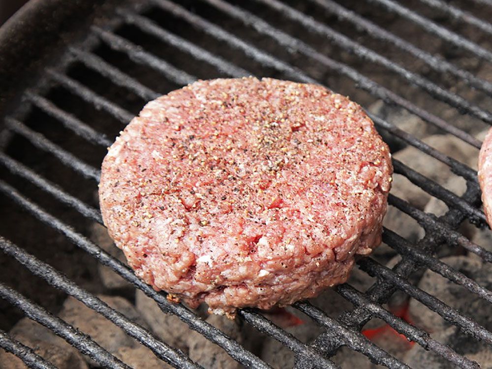 A bison burger patty on a grill. 