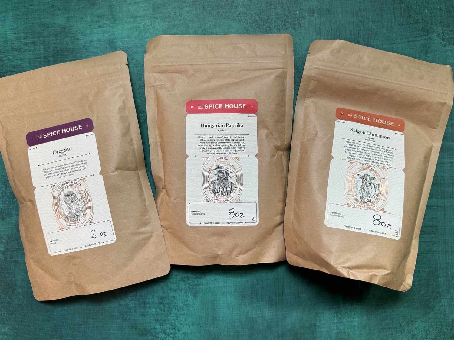 three packages of spice house spices on a blue green backdrop