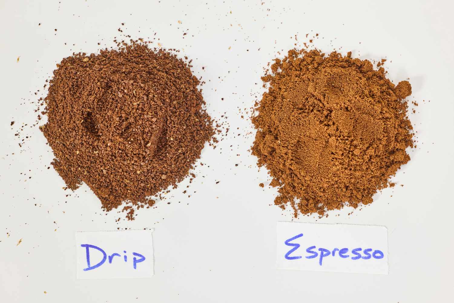 Two piles off coffee grounds. The one one the left is coarse and labeled "drip." The one on the right is fine and labeled "espresso."