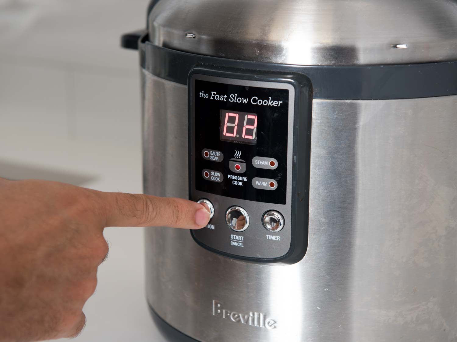 Person selecting an option on the Breville Slow Cooker. 