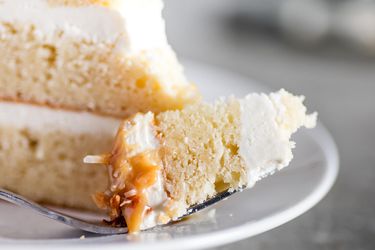 A forkful of coconut layer cake with creamy coconut frosting
