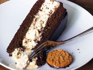 A slice of chocolate ginger peach icebox cake, served with a gingersnap.