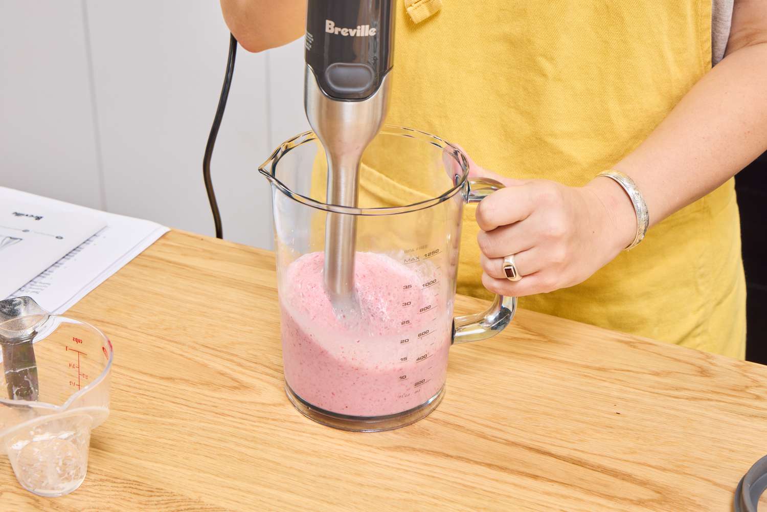 A person makes a smoothie using the Breville Control Grip Immersion Blender