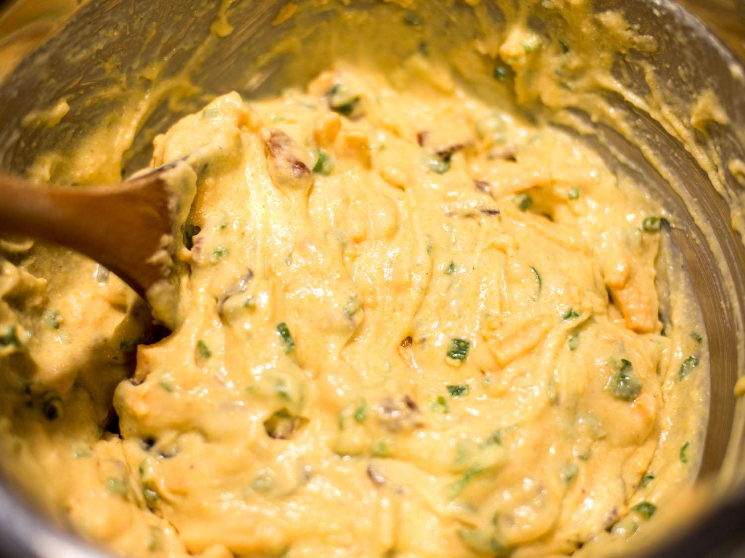 Mixing cheddar, bacon, and scallion cornbread batter.