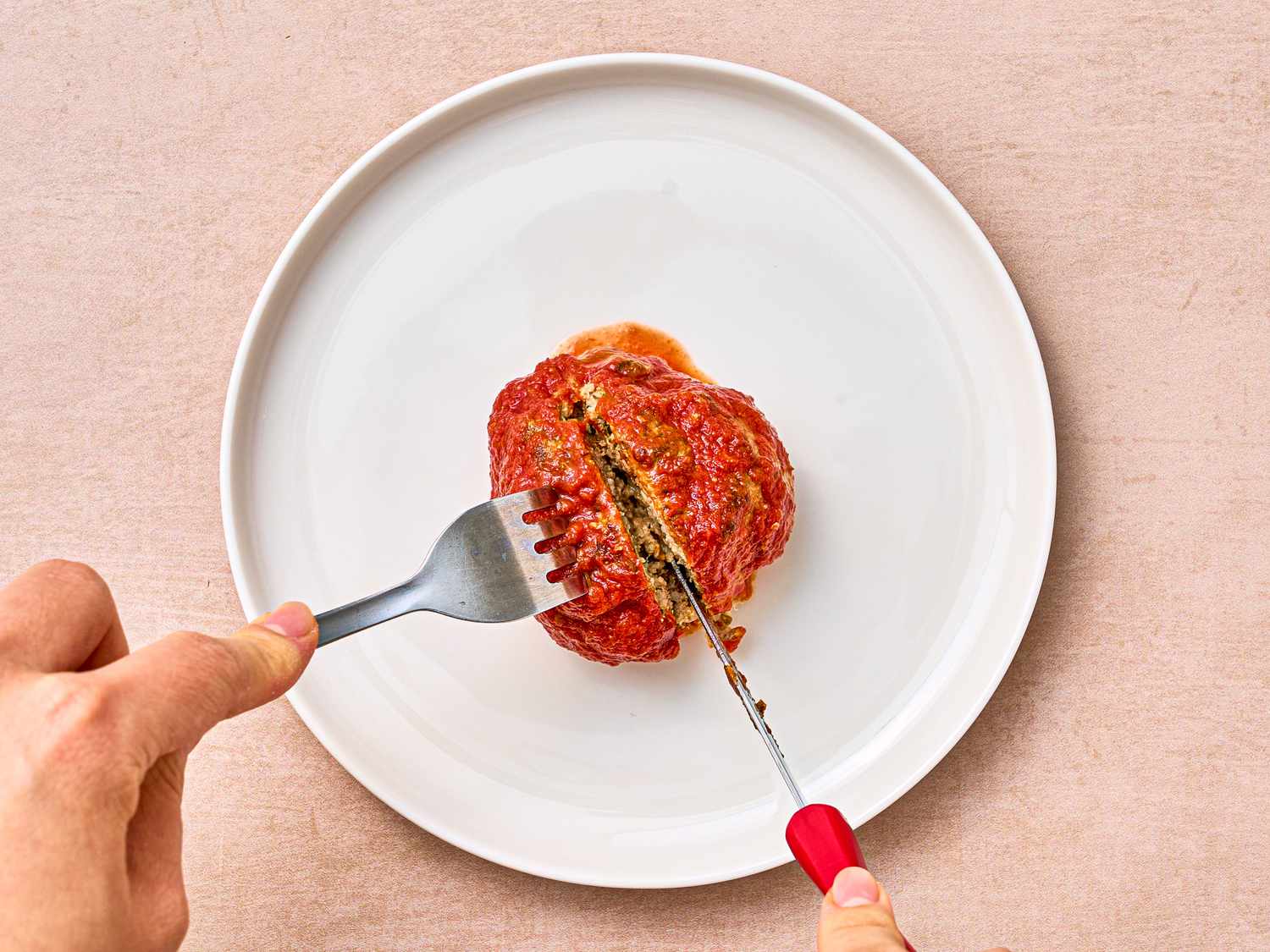 Overhead view of slicing meatball in half