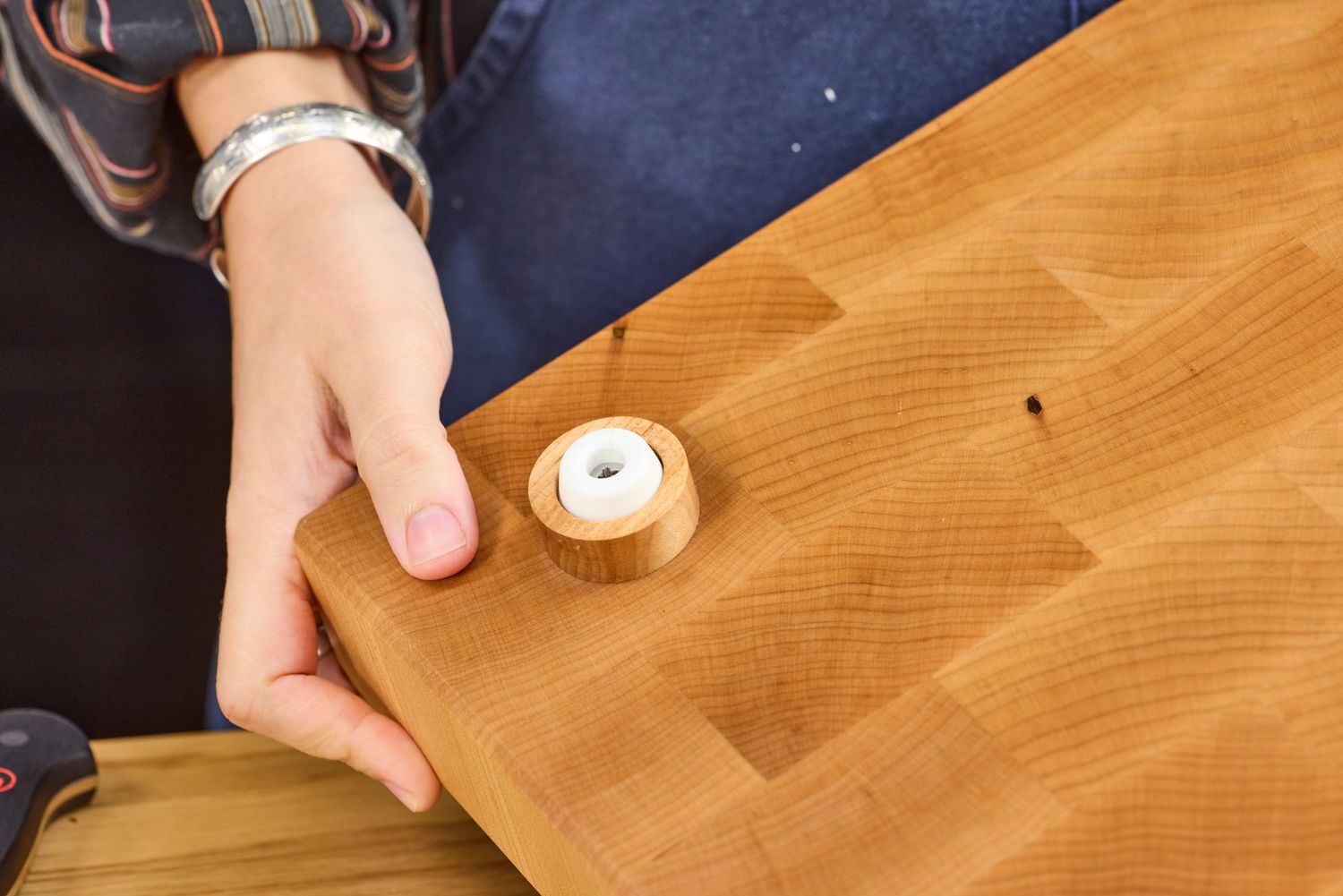 A person holding a Boardsmith Maple End-Grain Cutting Board