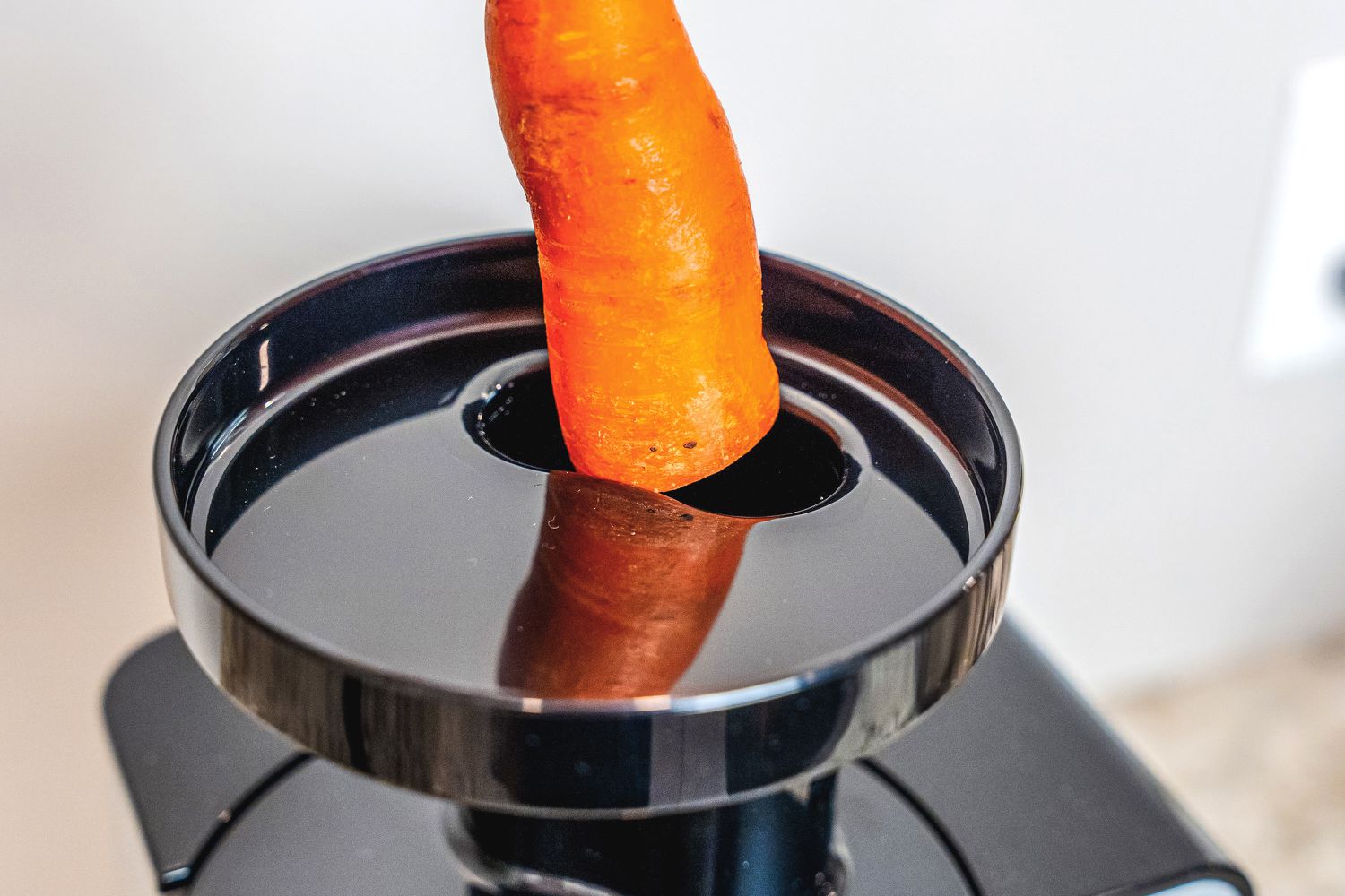 A carrot being added to the Omega juicer