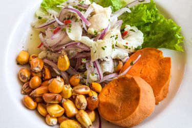 A platter of Peruvian ceviche with boiled corn and sweet potato.