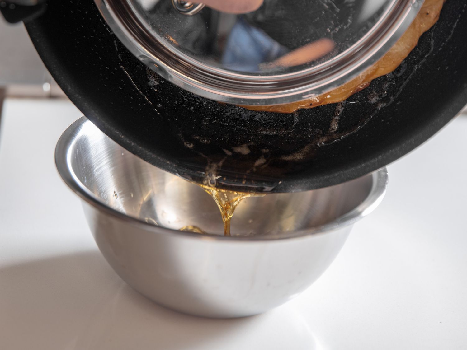 Pouring hot fat out of the skillet in preparation of the final inversion onto a serving plate