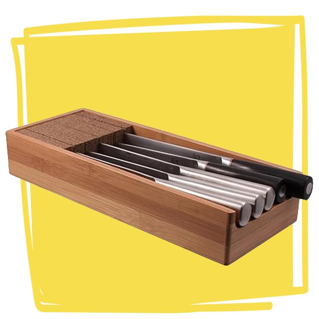 A bamboo knife drawer insert containing an arrangement of kitchen knives